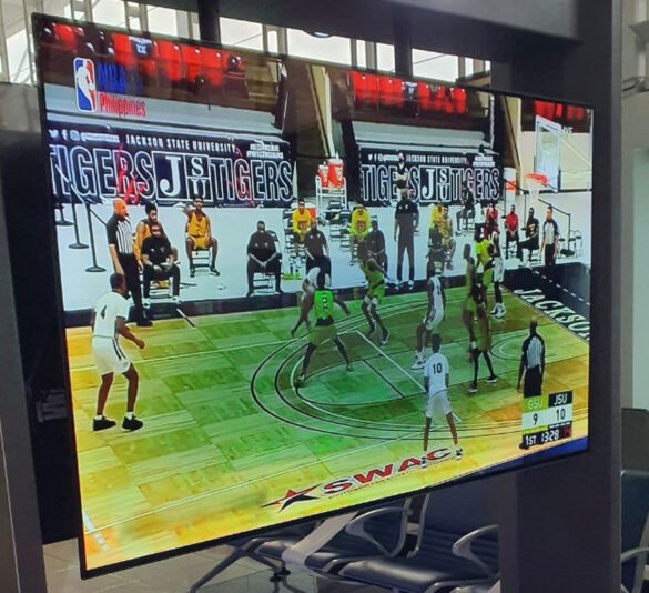 OLED TV at a local airport waiting area with burn-in, as evidenced by the dark shadow in the middle of the screen.